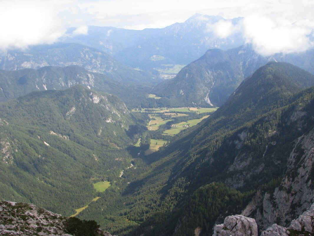 Pogled v dolino Krme in Zgornje Radovne (774 m) v smeri Jerebikovca (1593 m) na Mežakli in Mojstrane z Debele peči (2014 m), vzhodno ob predvrhu, ki je še zlasti cenjen med plezalci s smerjo Trapez