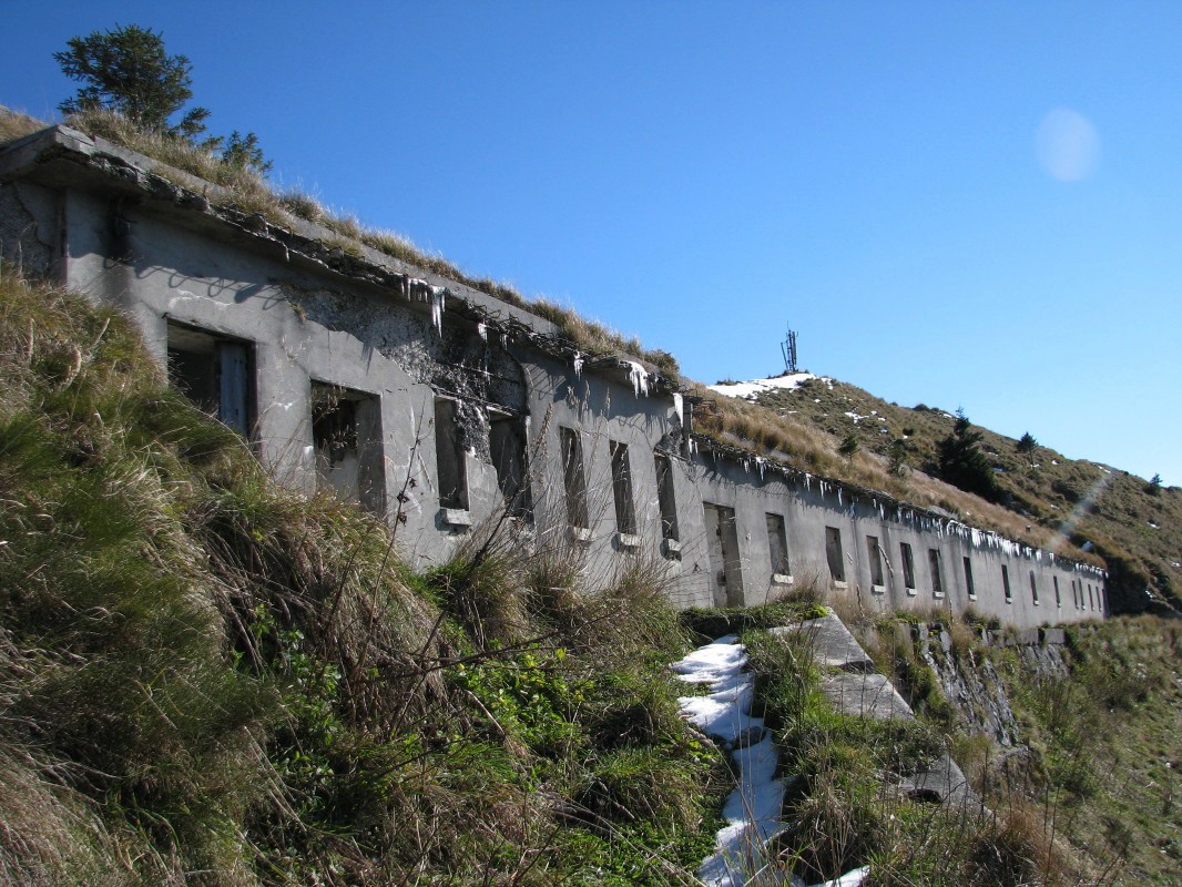 Ostanki dolge razpadajoče kaverne (s pročelja 22 okenskih lin in dva vhoda) v južnem pobočju Lajnarja (1549 m)
