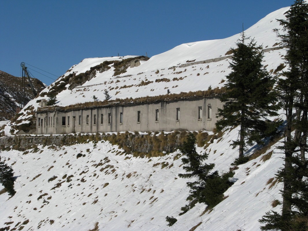 Ostanki dolge razpadajoče kaverne (s pročelja 22 okenskih lin in dva vhoda) v južnem pobočju Lajnarja (1549 m)