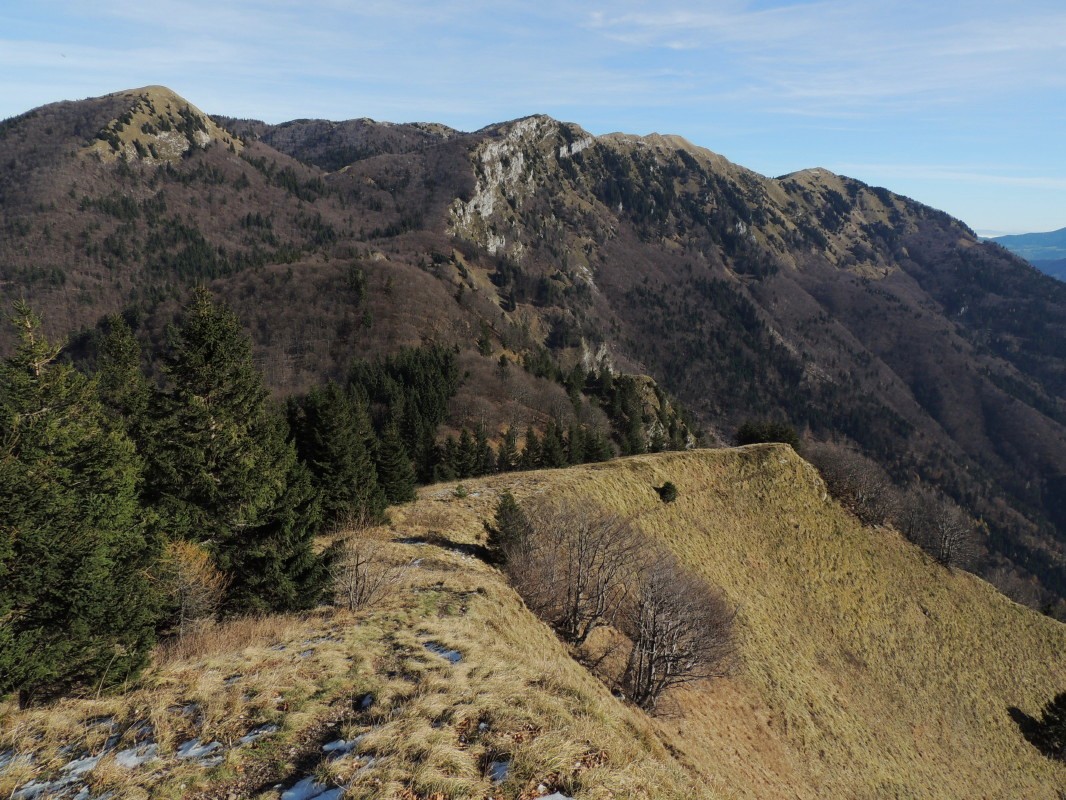 Pogled seže od Blegoša prek Porezna, Kojce, Črne prsti in naprej do Julijskih Alp, Karavank in vrhov nad Soriško planino