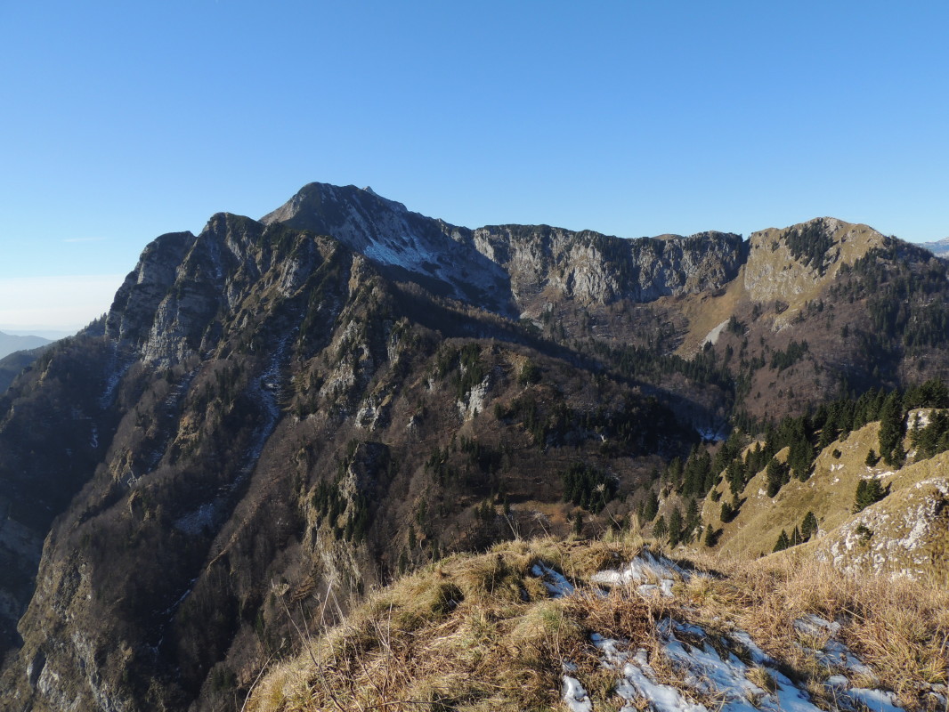 Pogled seže od Blegoša prek Porezna, Kojce, Črne prsti in naprej do Julijskih Alp, Karavank in vrhov nad Soriško planino