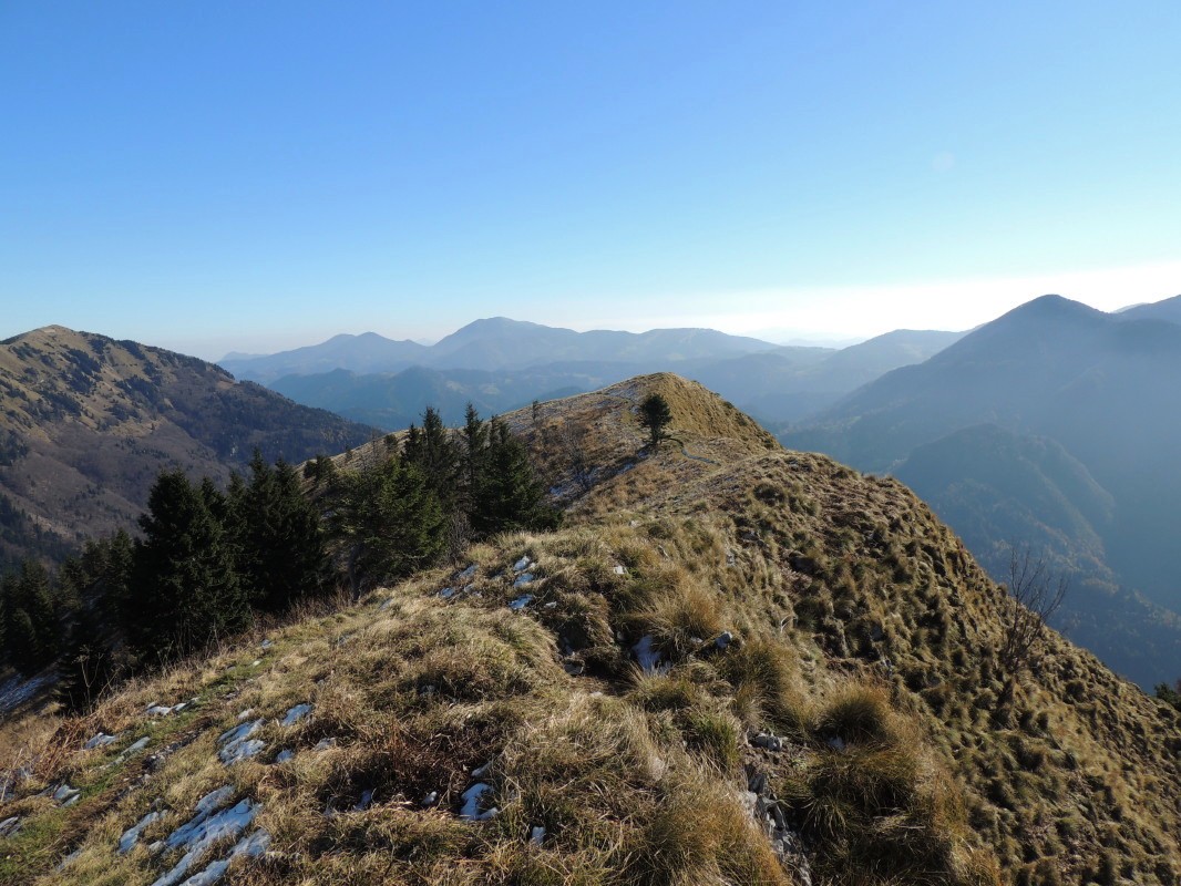 Pogled seže od Blegoša prek Porezna, Kojce, Črne prsti in naprej do Julijskih Alp, Karavank in vrhov nad Soriško planino - pogled na vrh Koble (1498 m)