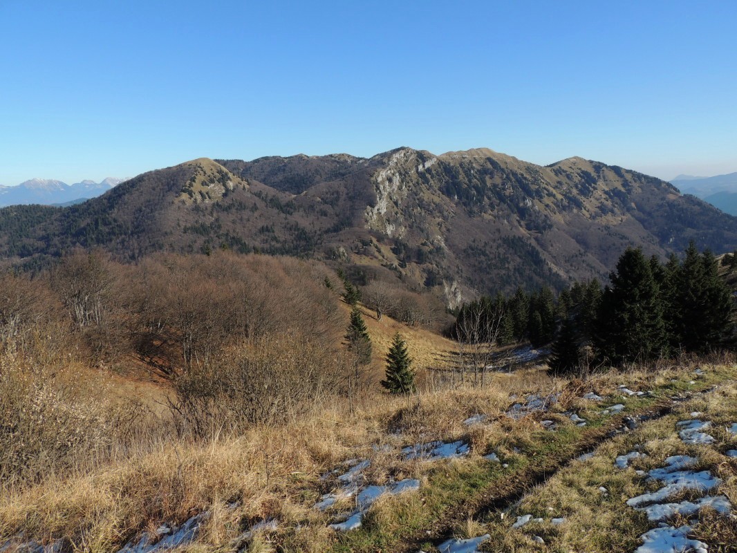 Pogled seže od Blegoša prek Porezna, Kojce, Črne prsti in naprej do Julijskih Alp, Karavank in vrhov nad Soriško planino - pogled na Bisagajev rovt (1370 m)